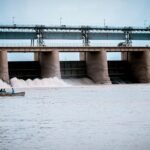 Hydroelectric dam in Jamshoro, Sindh with boat and people on Indus River.